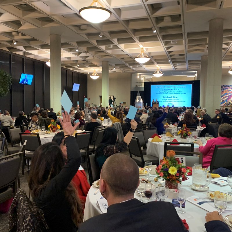 ballroom full of people sitting at dinner tables