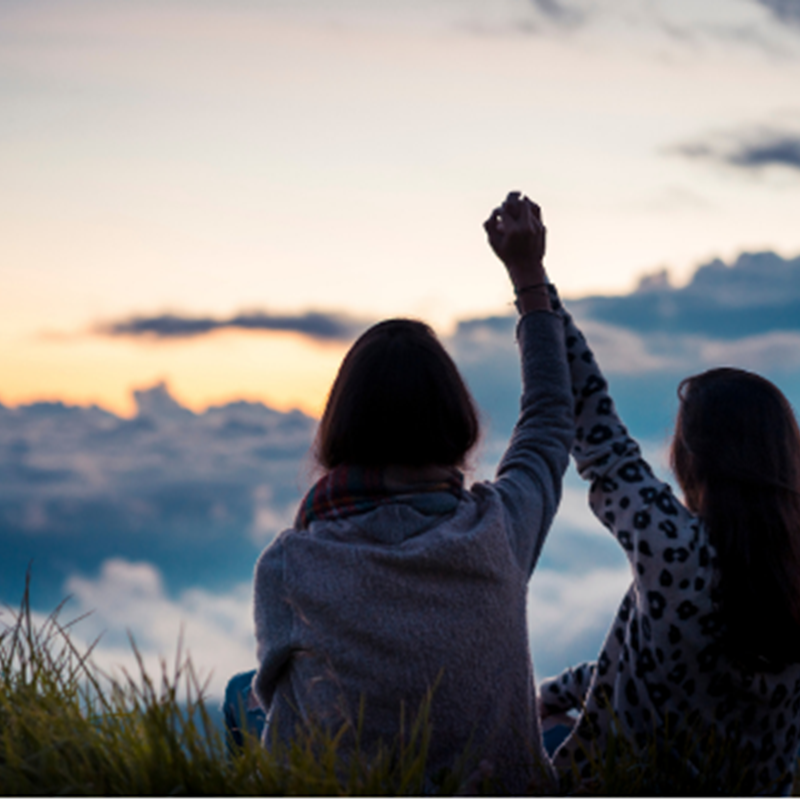 two women holding raised hands