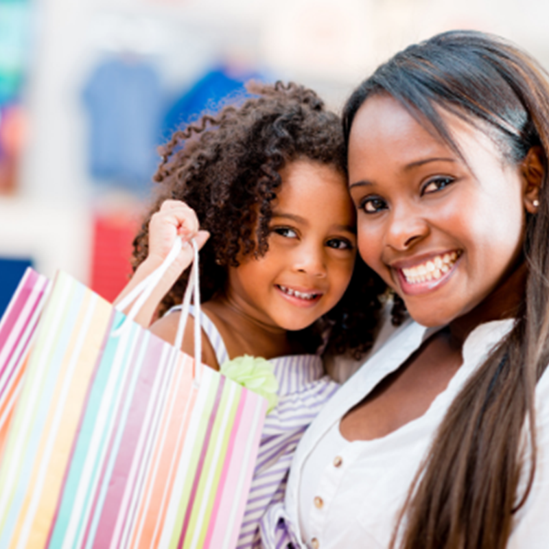 smiling woman with daughter holding striped gift bag
