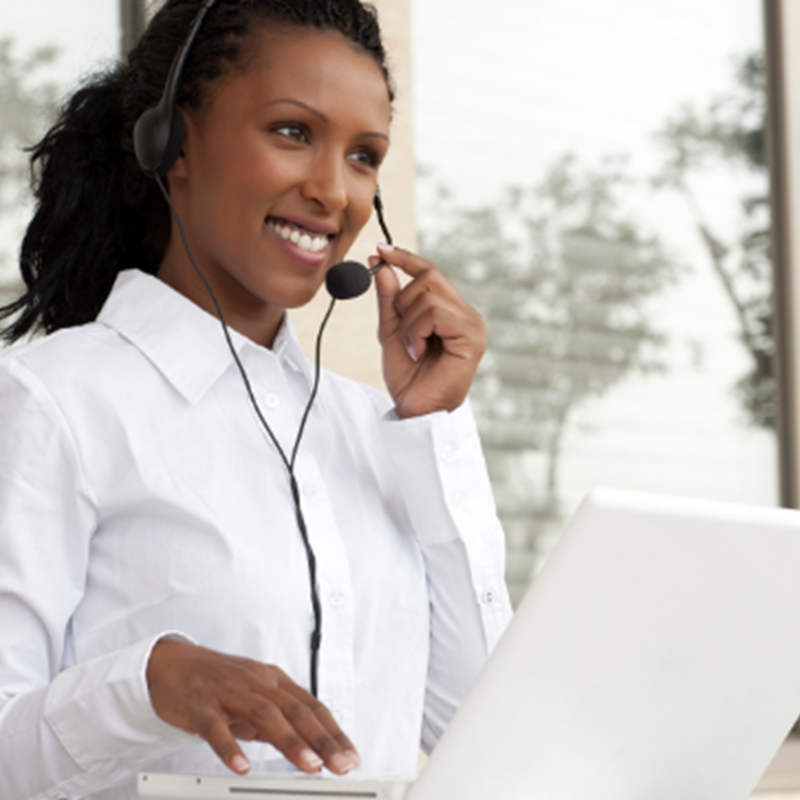 smiling woman wearing headset and using computer