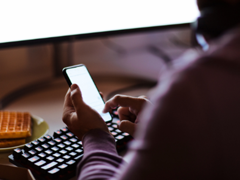 person using cellphone and computer