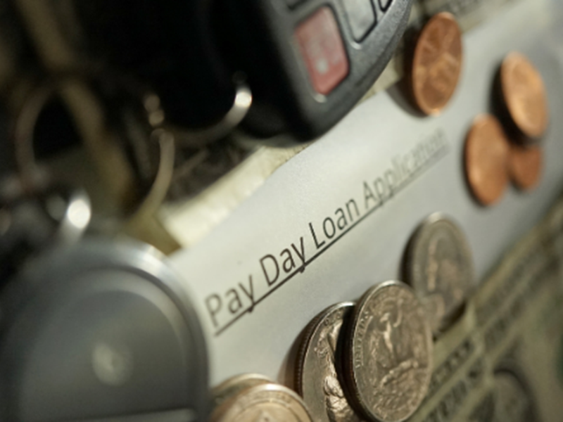 coins and car keys on top a Pay Day Loan Application
